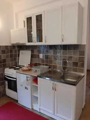 a kitchen with white cabinets and a sink at Andrej Apartments in Kotor