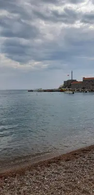 a body of water with a building in the background at BOK HOLIDAY HOME Petrovac in Petrovac na Moru