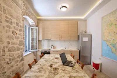 a kitchen with a table with a laptop on it at CENTRUM HOSTEL in Kotor