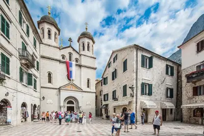 a group of people walking in a street in front of buildings at CENTRUM HOSTEL in Kotor