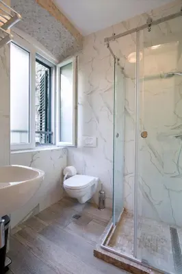a bathroom with a shower and a toilet and a sink at CENTRUM HOSTEL in Kotor