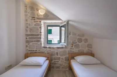 two twin beds in a room with a window at CENTRUM HOSTEL in Kotor