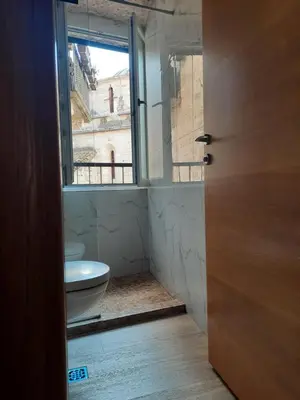 a bathroom with a toilet and a window at CENTRUM HOSTEL in Kotor