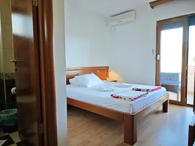 a bedroom with a bed and a door to a balcony at Villa Krivokapić Budva in Budva