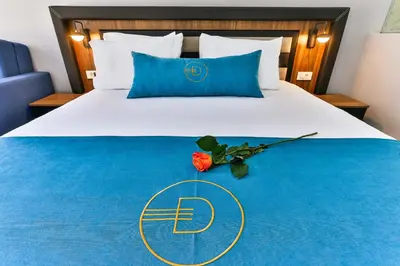 a hotel room with a bed with a flower on it at Dulamerovic Resort in Bar