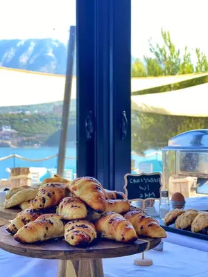 a table with a tray of bread on a table at Dulamerovic Resort in Bar