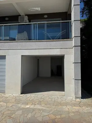 a garage under a house with a balcony at Tophill Altezza Premium - best view and pool in Budva
