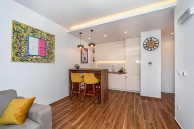 a kitchen and living room with a table and chairs at Accordion Apartment in Bar