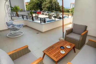 a balcony with a table and chairs on a roof at Accordion Apartment in Bar