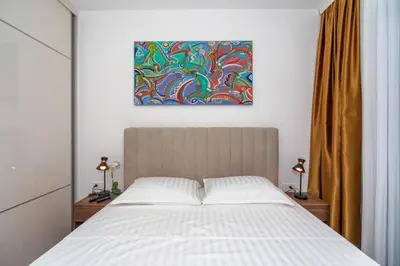 a bedroom with a bed and a painting on the wall at Accordion Apartment in Bar
