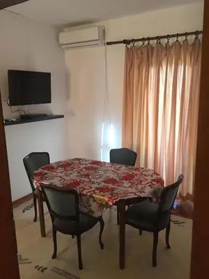 a dining room with a table and chairs and a television at Apartman-Fenix in Bar, Susanj