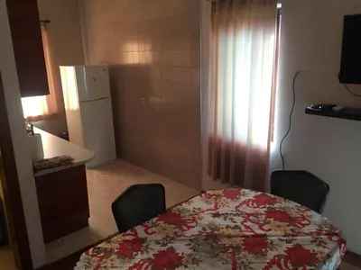 a kitchen with a table and chairs and a refrigerator at Apartman-Fenix in Bar, Susanj