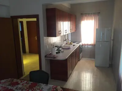 a kitchen with wooden cabinets and a white refrigerator at Apartman-Fenix in Bar, Susanj