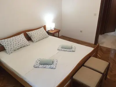 a bed with two pillows and two chairs in a room at Apartman-Fenix in Bar, Susanj