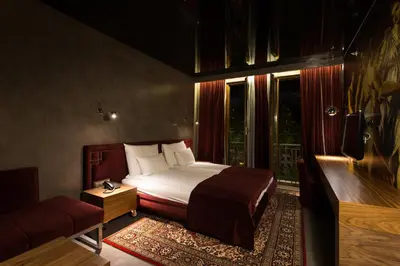 a bedroom with a bed and a couch and a television at Hotel Hemera in Podgorica