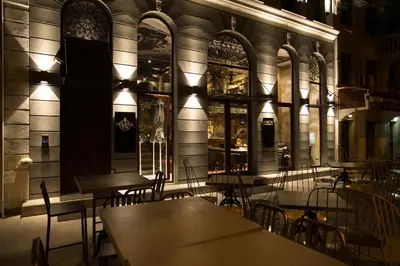 a restaurant with tables and chairs in front of a building at Hotel Hemera in Podgorica