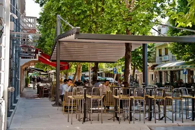 a group of people sitting at an outdoor cafe at Hotel Hemera in Podgorica