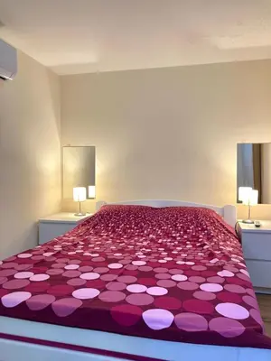 a bedroom with a large bed with pink and white covers at Podgorica-Downtown in Podgorica