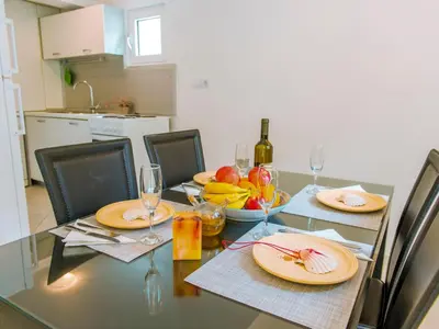a dining table with plates of food and wine glasses at Green Home Apartments in Kotor