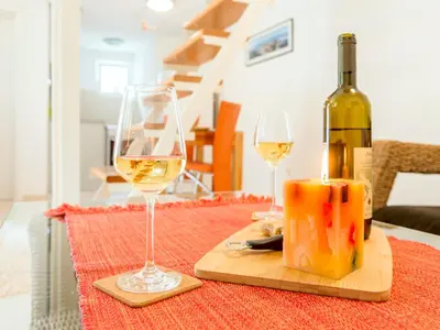 a bottle of wine and two glasses on a table at Green Home Apartments in Kotor