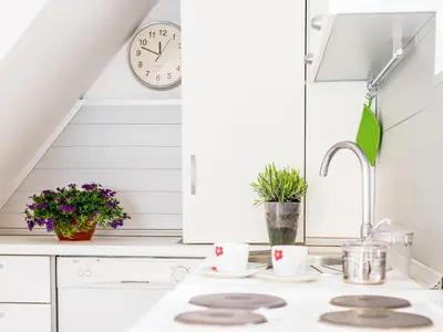 a white kitchen with a sink and a clock at Green Home Apartments in Kotor