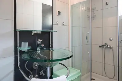 a bathroom with a glass sink and a shower at Green Home Apartments in Kotor