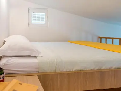 a bed with white sheets and a window in a room at Green Home Apartments in Kotor
