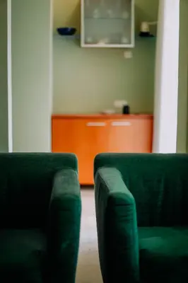two green chairs in a living room with a cabinet at Villa Casa di Pietra - Budva Old town in Budva