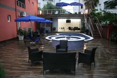 a patio with a pool and chairs and umbrellas at VilaElenaMarko in Budva