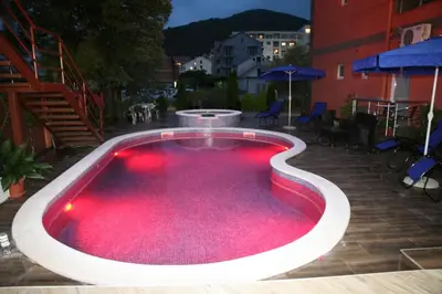 a large swimming pool with red lighting on a patio at VilaElenaMarko in Budva