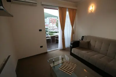 a living room with a couch and a glass table at VilaElenaMarko in Budva
