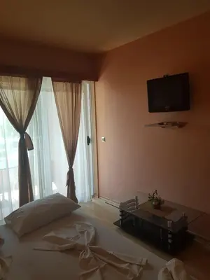 a bedroom with a bed and a tv on the wall at VilaElenaMarko in Budva