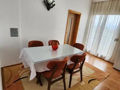 a dining room table with chairs and a vase on it at Apartment Dukić in Bar