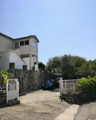 a house with a car parked in front of a fence at Apartment Dukić in Bar