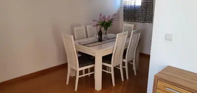a white dining room table with chairs and a bottle of wine at Elena in Bar