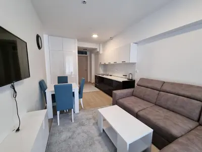 a living room with a couch and a table at Prestige Central apartments - Rafailovici in Budva