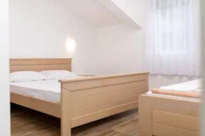 a white bedroom with a bed and a window at Apartments Budva Center 2 in Budva