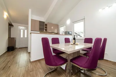a dining room with purple chairs and a table at Apartments Budva Center 2 in Budva