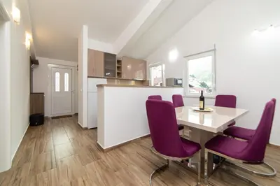 a kitchen and dining room with a table and purple chairs at Apartments Budva Center 2 in Budva