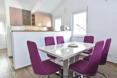 a dining room with purple chairs and a white table at Apartments Budva Center 2 in Budva