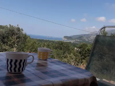 two coffee cups sitting on a table with a view at Adriatic Sunset House in Petrovac na Moru