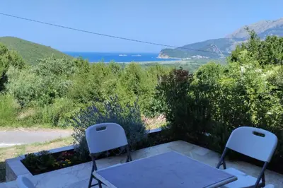 two chairs and a table on a patio with a view at Adriatic Sunset House in Petrovac na Moru