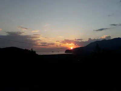 a sunset with the sun setting over the ocean at Adriatic Sunset House in Petrovac na Moru
