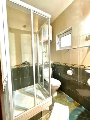 a bathroom with a glass shower and a toilet at Apartments Petkovic Budva in Budva