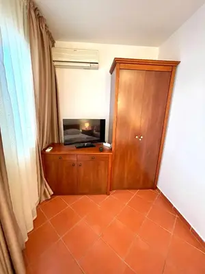 a room with a television and a wooden cabinet at Apartments Petkovic Budva in Budva
