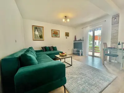 a living room with a green couch and a table at Parapid Apartments Budva in Budva