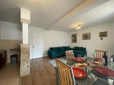 a living room with a table and a green couch at Parapid Apartments Budva in Budva