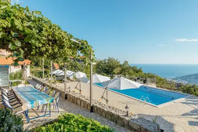a swimming pool with a table and chairs next to at Villa Marija **** with private pool in Budva