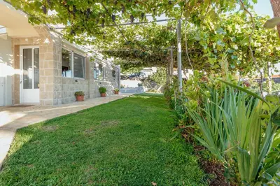 a yard with green grass in front of a building at Villa Marija **** with private pool in Budva