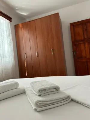 a bedroom with towels on a bed with a wardrobe at Villa Marija **** with private pool in Budva